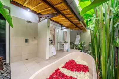 a bath tub filled with red flowers in a bathroom at Paradise in the Heart of Seminyak! in Seminyak
