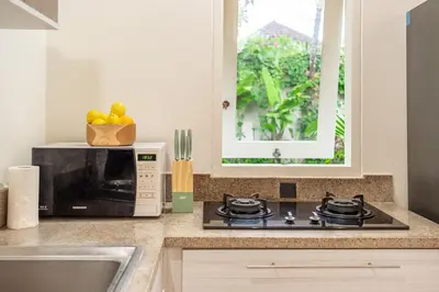 a kitchen with a microwave and a stove top oven at Paradise in the Heart of Seminyak! in Seminyak