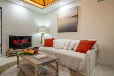 a living room with a white couch and a table at Paradise in the Heart of Seminyak! in Seminyak