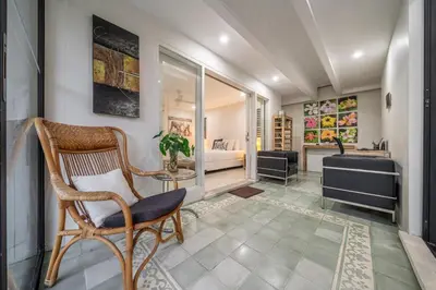 a living room with a chair and a bedroom at Paradise in the Heart of Seminyak! in Seminyak