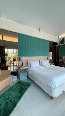a bedroom with a large bed with a green wall at Bougenvilla Nusa Dua Villa with Private Pool in Nusa Dua