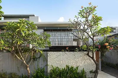 a house with a fence and trees in front of it at Bougenvilla Nusa Dua Villa with Private Pool in Nusa Dua