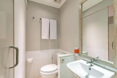 a bathroom with a sink and a toilet and a mirror at Cove Renata in Seminyak