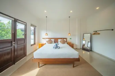 a bedroom with a bed and a large window at Modern and Quiet 2BR Villa in Seminyak Central with Private Pool in Denpasar