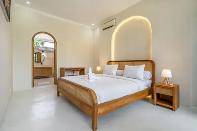 a bedroom with a large bed with a large arch above it at Villa Ocean Bali in Seminyak