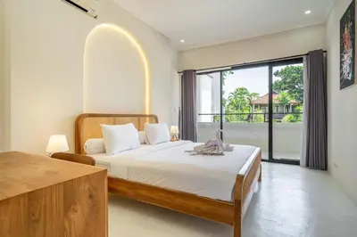 a bedroom with a bed and a large window at Villa Ocean Bali in Seminyak