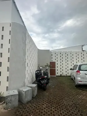 a motorcycle parked in a parking lot next to a building at bali thousand island living - guest house in Pesanggaran