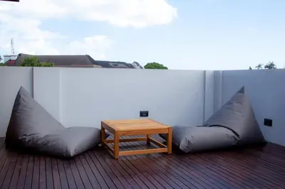 a patio with a couch and a table on a balcony at Ducat Living in Canggu