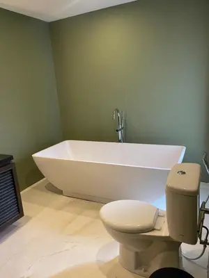 a bathroom with a white tub and a toilet at Ducat Living in Canggu