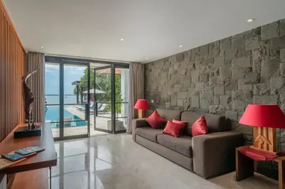 a living room with a couch with red pillows at Beachfront Escape Villa in Ujung