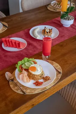 a table with plates of food on a wooden table at Beachfront Escape Villa in Ujung