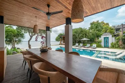 a dining room with a table and chairs and a pool at Beachfront Escape Villa in Ujung