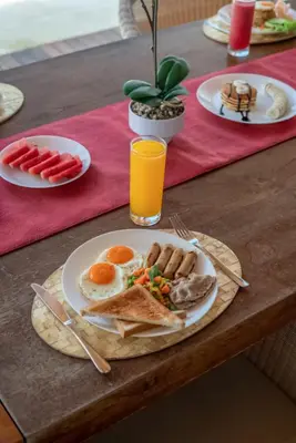 a table with a plate of breakfast food on it at Beachfront Escape Villa in Ujung