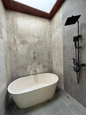 a white bath tub in a bathroom with a ceiling at Ozzy Bali Villa 3 in Seminyak