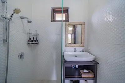 a white bathroom with a sink and a shower at Adamo villa Seminyak in Seminyak
