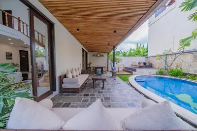 an outdoor patio with a swimming pool and a house at Adamo villa Seminyak in Seminyak