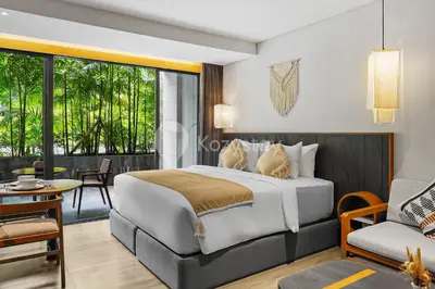 a bedroom with a bed and a living room at Aranya by Kozystay - Nusa Dua in Nusa Dua