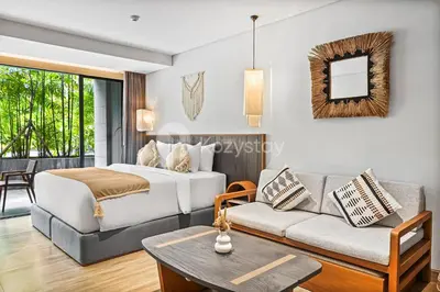 a hotel room with a bed and a couch at Aranya by Kozystay - Nusa Dua in Nusa Dua