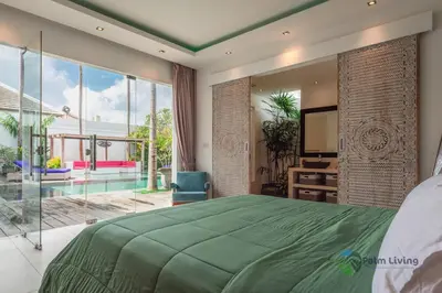 a bedroom with a green bed and a large window at Villa Babar in Canggu