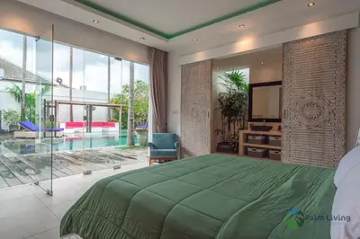 a bedroom with a large green bed and a tv at Villa Babar in Canggu