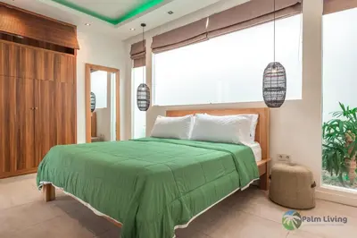 a bedroom with a green bed and a large window at Villa Babar in Canggu