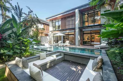 a house with a swimming pool in the backyard at Stylish 5BR Designer Villa, 400m to the Ocean in Canggu