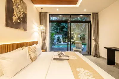 a bedroom with a large bed and a large window at Stylish 5BR Designer Villa, 400m to the Ocean in Canggu