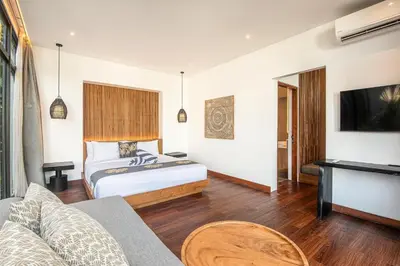 a hotel room with a bed and a tv at Elegant 5BR Tropical Escape Just 400m to Beach in Canggu