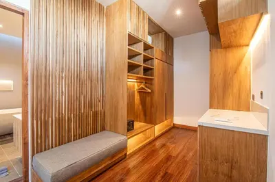 a room with a wooden wall with a bench in it at Elegant 5BR Tropical Escape Just 400m to Beach in Canggu