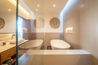 a bathroom with two toilets and a tub and a sink at Elegant 5BR Tropical Escape Just 400m to Beach in Canggu