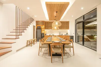 a dining room with a long table and chairs at Elegant 5BR Modern Villa Steps from Café Del Mar in Canggu