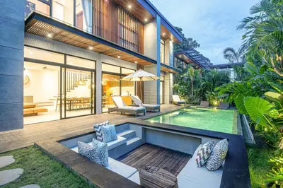 an external view of a house with a swimming pool at Elegant 5BR Modern Villa Steps from Café Del Mar in Canggu