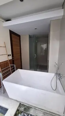 a large white bath tub with a shower in a bathroom at NOWACs SASADARA in Canggu
