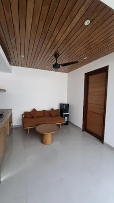 a living room with a couch and a wooden ceiling at NOWACs SASADARA in Canggu