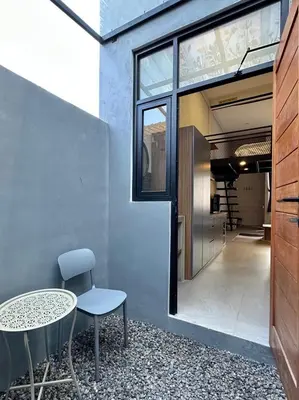 a table and a chair sitting next to a building at De Kamar Mezzanine in Denpasar