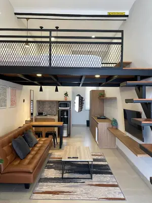 a living room with a couch and a table at De Kamar Mezzanine in Denpasar