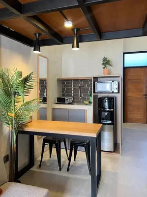 a kitchen with a wooden table with chairs and a table at De Kamar Mezzanine in Denpasar