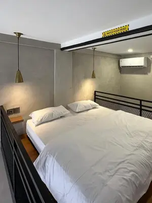 a bedroom with a large white bed with two pillows at De Kamar Mezzanine in Denpasar