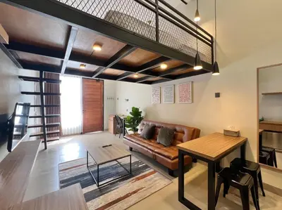 a living room with a couch and a loft at De Kamar Mezzanine in Denpasar