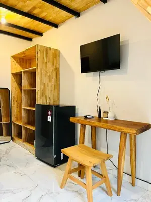 a room with a table and a television on a wall at Persada Loft Bali in Seminyak