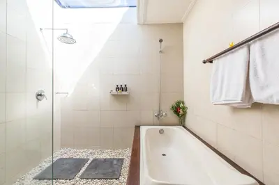 a white bathroom with a tub and a shower at Villa Sedap Malam Seminyak by Best Deals Asia Hospitality in Seminyak