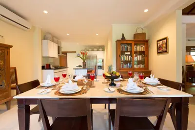 a large dining room table with chairs and wine glasses at Villa Balidamai in Kerobokan