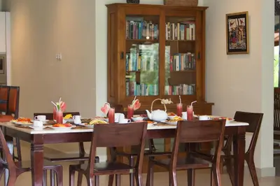 a dining room with a table with food and candles at Villa Balidamai in Kerobokan
