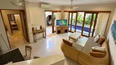 a large living room with a couch and a television at Villa Anyelir in Seminyak