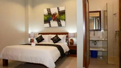 a hotel room with a bed and a bathroom at Villa Anyelir in Seminyak