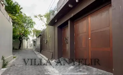 a couple of wooden garage doors on a street at Villa Anyelir in Seminyak