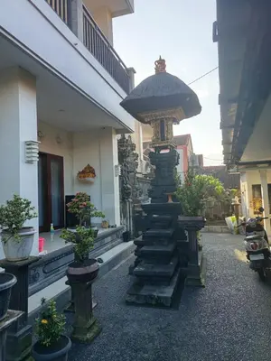 a stone pillar with a clock on top of it at Erick house in Seminyak