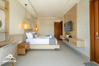 a bedroom with a bed and a desk in it at Serayu Berawa by Bukit Vista in Canggu