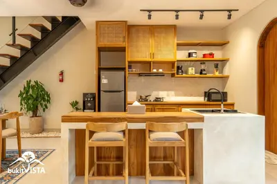 a kitchen with a counter with stools at Serayu Berawa by Bukit Vista in Canggu