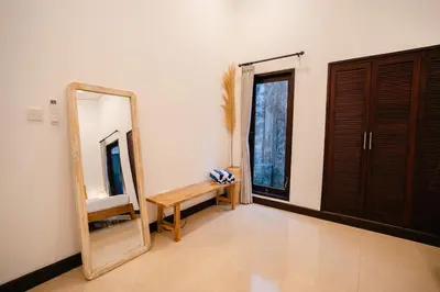 a dressing room with a mirror and a wooden bench at Villa Kirari in Seminyak